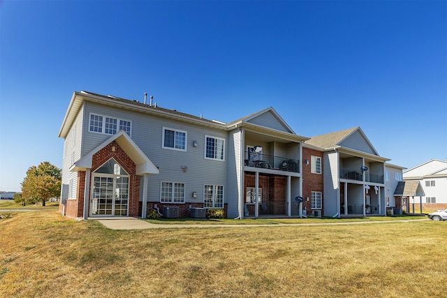 1325 SE Florence Dr Unit 207, Waukee, IA 50263 - back of house with brick siding, a lawn, and central AC unit