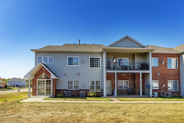 1325 SE Florence Dr Unit 207, Waukee, IA 50263 - rear view of property featuring a balcony, a yard, and brick siding