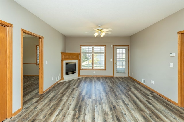 1325 SE Florence Dr Unit 207, Waukee, IA 50263 - unfurnished living room featuring ceiling fan, wood finished floors, a tiled fireplace, and baseboards