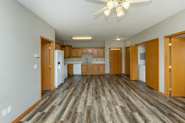 1325 SE Florence Dr Unit 207, Waukee, IA 50263 - kitchen featuring white appliances, a sink, dark wood-type flooring, light countertops, and a textured ceiling