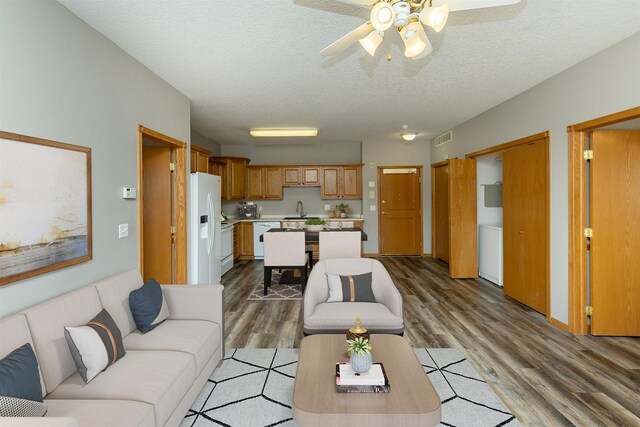 1325 SE Florence Dr Unit 207, Waukee, IA 50263 - living area featuring wood finished floors, a textured ceiling, and a ceiling fan