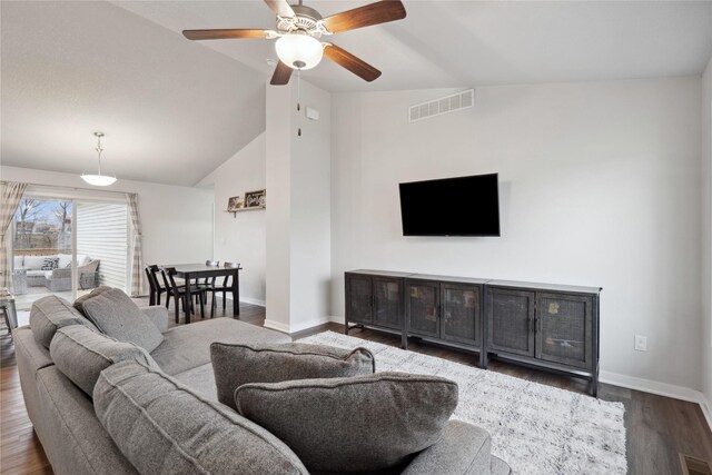 living area with visible vents, baseboards, ceiling fan, wood finished floors, and lofted ceiling