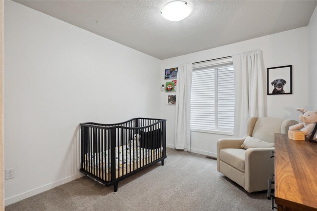 carpeted bedroom featuring baseboards, a textured ceiling, visible vents, and a nursery area