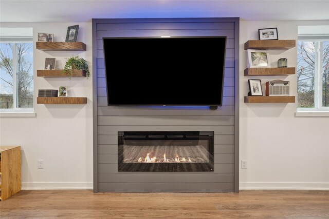 interior details featuring baseboards, a fireplace, and wood finished floors