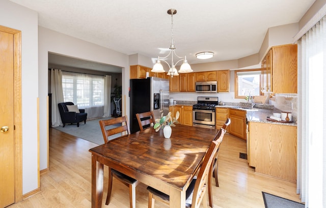 15026 Hawthorn Dr, Clive, IA 50325 - dining room featuring healthy amount of natural light, light wood-type flooring, and a chandelier