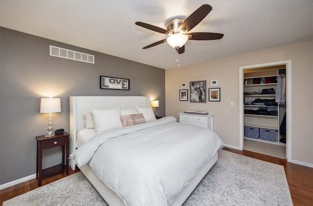 15026 Hawthorn Dr, Clive, IA 50325 - bedroom featuring wood finished floors, a walk in closet, baseboards, and a closet