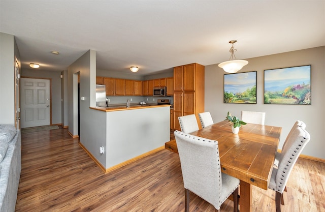 dining room with light wood-type flooring and baseboards