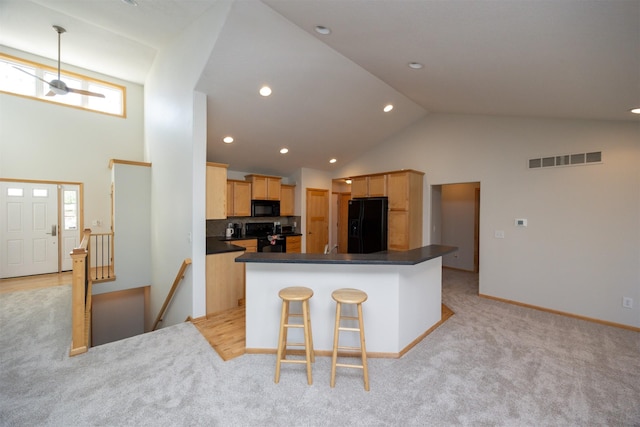 4328 125th St, Urbandale, IA 50323 - kitchen with black appliances, high vaulted ceiling, light carpet, dark countertops, and a center island