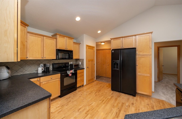 4328 125th St, Urbandale, IA 50323 - kitchen with black appliances, vaulted ceiling, light wood finished floors, dark countertops, and light brown cabinetry
