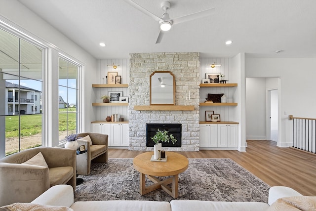 1284 NW 29th Ct, Grimes, IA 50111 - living area featuring ceiling fan, wood finished floors, and a stone fireplace