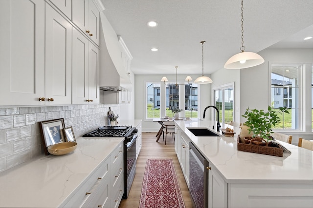 1284 NW 29th Ct, Grimes, IA 50111 - kitchen featuring gas range oven, stainless steel dishwasher, a kitchen island with sink, decorative backsplash, and white cabinetry