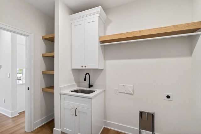 1284 NW 29th Ct, Grimes, IA 50111 - laundry area with electric dryer hookup, wood finished floors, and cabinet space
