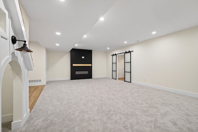 1284 NW 29th Ct, Grimes, IA 50111 - basement featuring carpet floors, a barn door, recessed lighting, and a large fireplace