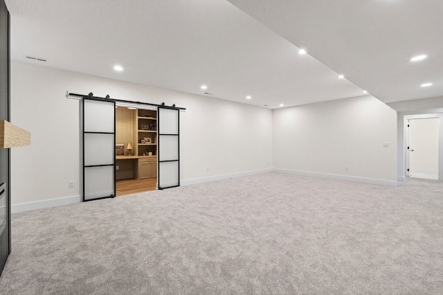 1284 NW 29th Ct, Grimes, IA 50111 - basement featuring light carpet, a barn door, and recessed lighting