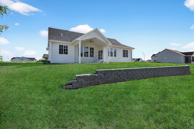 1284 NW 29th Ct, Grimes, IA 50111 - back of house featuring ceiling fan, a yard, board and batten siding, and roof with shingles
