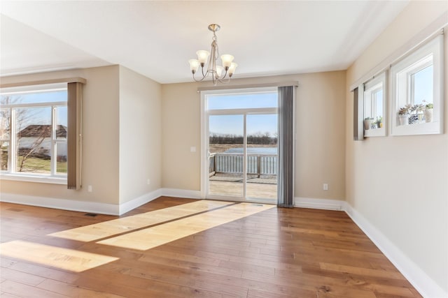 7821 NW 96th St, Johnston, IA 50131 - spare room with a chandelier, hardwood / wood-style floors, and baseboards