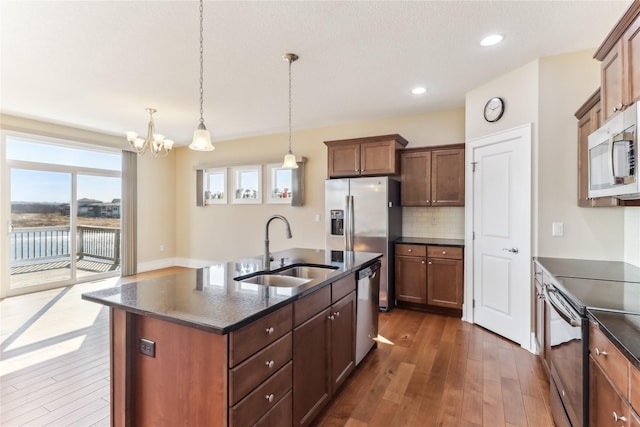 7821 NW 96th St, Johnston, IA 50131 - kitchen with a sink, appliances with stainless steel finishes, dark wood finished floors, decorative backsplash, and recessed lighting