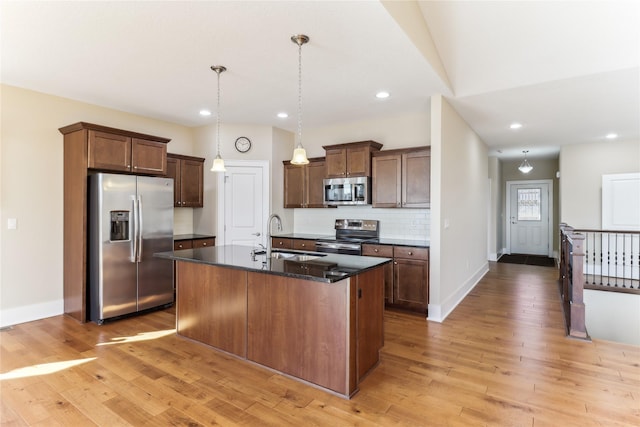 7821 NW 96th St, Johnston, IA 50131 - kitchen featuring appliances with stainless steel finishes, a sink, light wood-style floors, tasteful backsplash, and baseboards