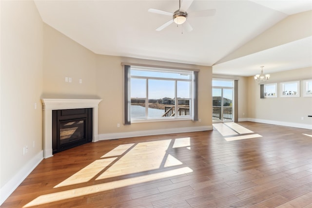 7821 NW 96th St, Johnston, IA 50131 - unfurnished living room featuring a chandelier, a glass covered fireplace, lofted ceiling, wood finished floors, and a ceiling fan
