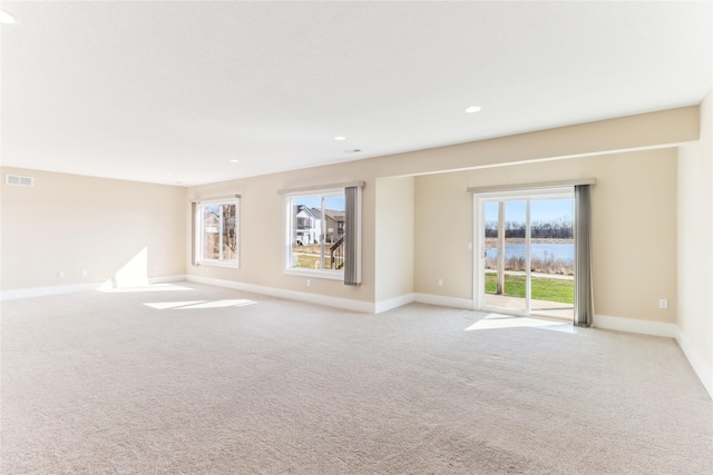 7821 NW 96th St, Johnston, IA 50131 - unfurnished room with a water view, plenty of natural light, light carpet, baseboards, and recessed lighting