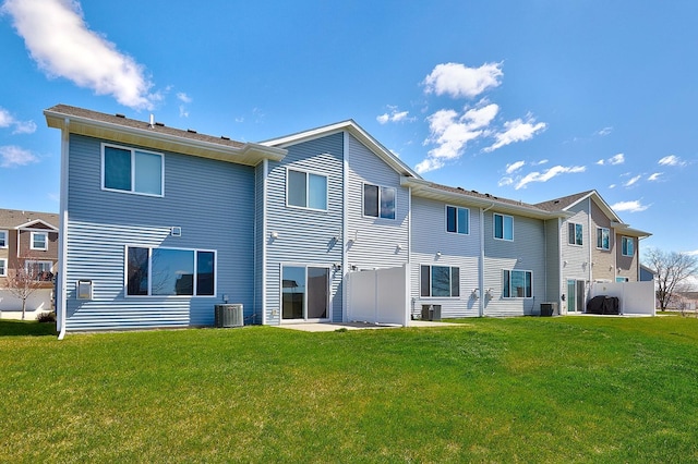 back of house with a lawn and central AC unit