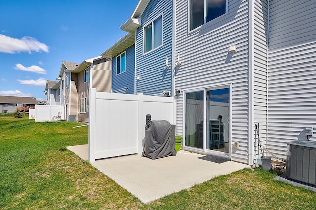 rear view of house with central AC, a yard, fence, and a patio area