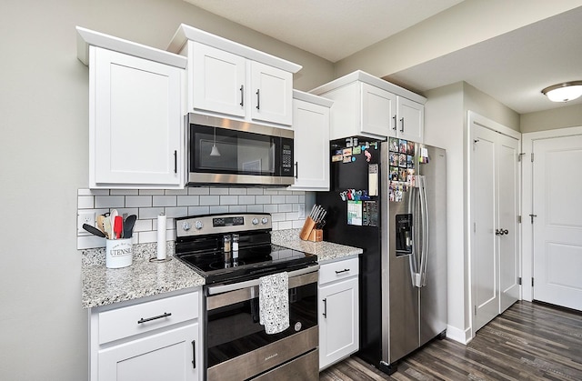 kitchen featuring light stone counters, decorative backsplash, stainless steel appliances, white cabinets, and dark wood-style floors