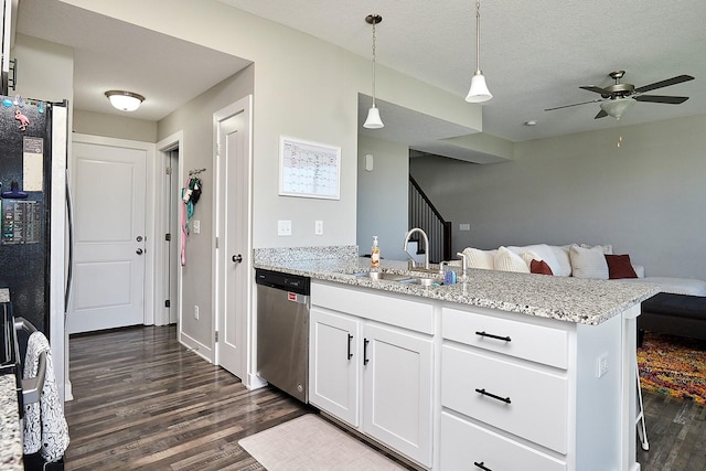 kitchen featuring dishwasher, a sink, a peninsula, open floor plan, and dark wood-style flooring