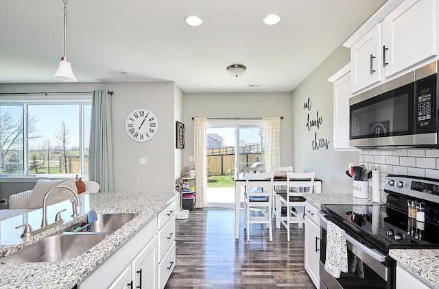 kitchen with a sink, stainless steel appliances, white cabinetry, dark wood-type flooring, and recessed lighting