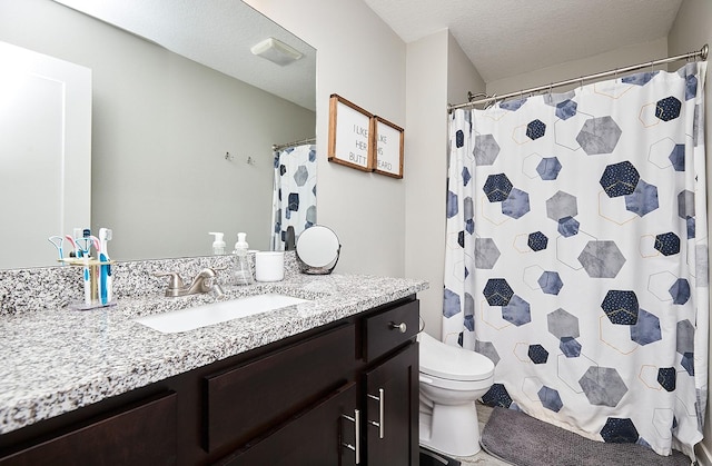 full bathroom featuring a textured ceiling, toilet, and vanity