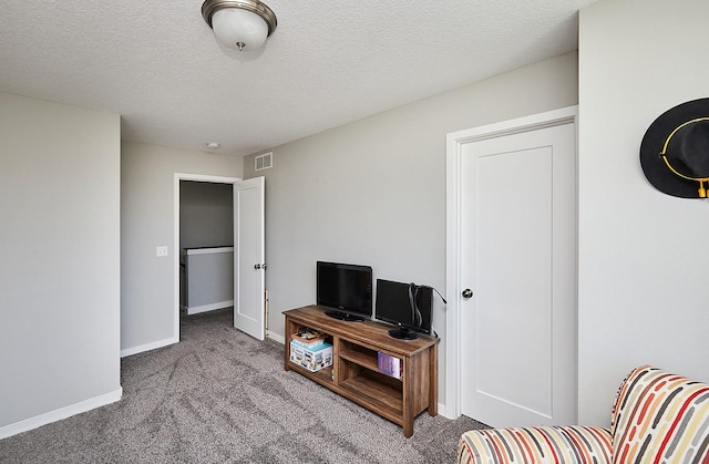 carpeted living room with baseboards, visible vents, and a textured ceiling
