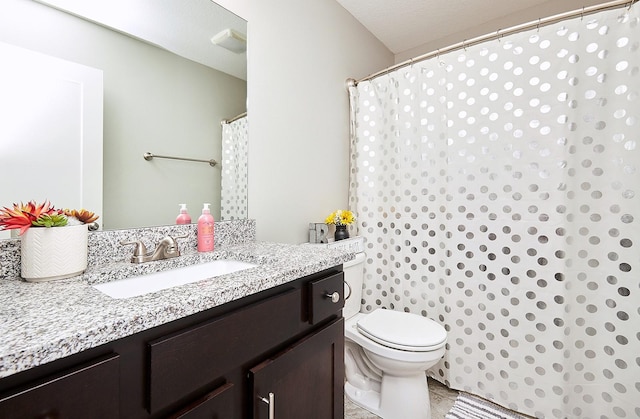 bathroom with vanity, curtained shower, and toilet