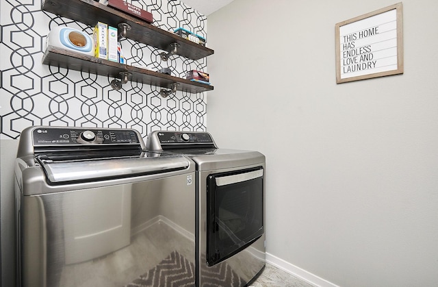 clothes washing area with washer and dryer, baseboards, and laundry area