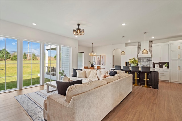 25019 Eagle Vista Dr, Adel, IA 50003 - living area featuring a chandelier, arched walkways, recessed lighting, and light wood-style floors