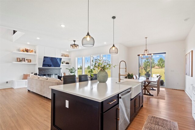25019 Eagle Vista Dr, Adel, IA 50003 - kitchen with stainless steel dishwasher, a chandelier, light countertops, light wood-type flooring, and an island with sink