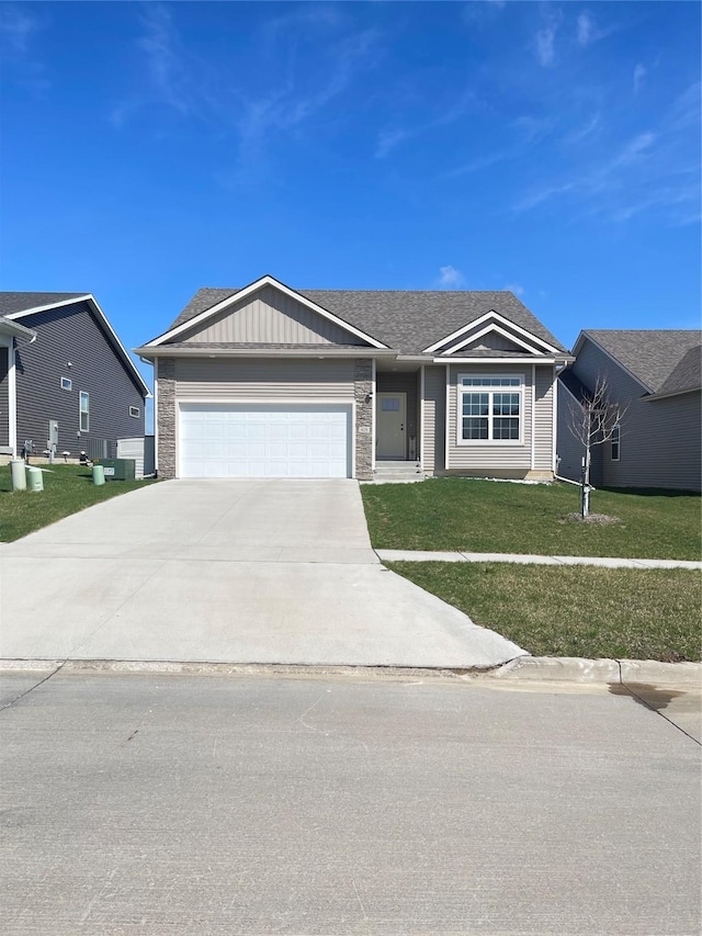425 SE Hollow Ct, West Des Moines, IA 50265 - ranch-style house with board and batten siding, an attached garage, driveway, and a front lawn