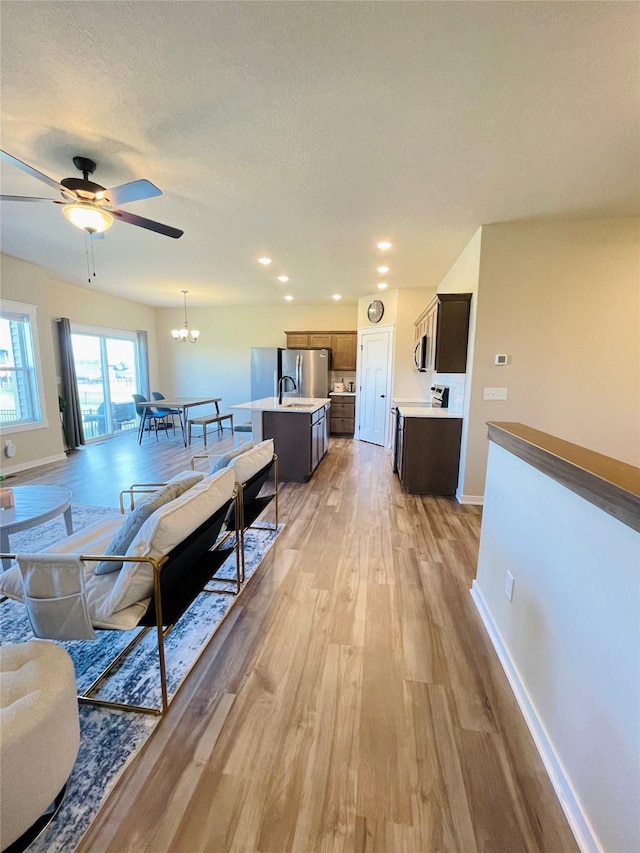 425 SE Hollow Ct, West Des Moines, IA 50265 - living room with recessed lighting, baseboards, light wood finished floors, and ceiling fan with notable chandelier