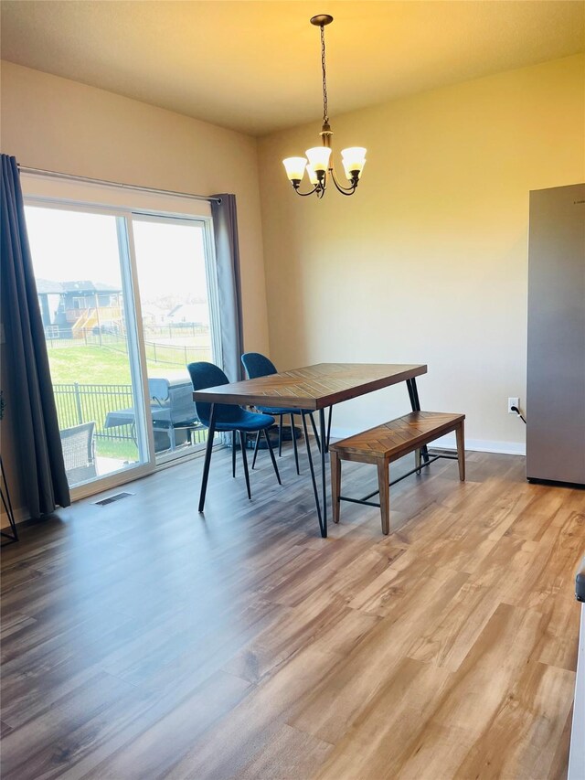 425 SE Hollow Ct, West Des Moines, IA 50265 - dining room with baseboards, visible vents, an inviting chandelier, and light wood-style floors