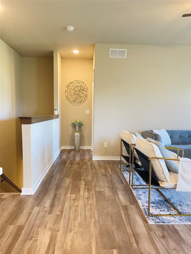 425 SE Hollow Ct, West Des Moines, IA 50265 - sitting room featuring visible vents, wood finished floors, baseboards, an upstairs landing, and recessed lighting