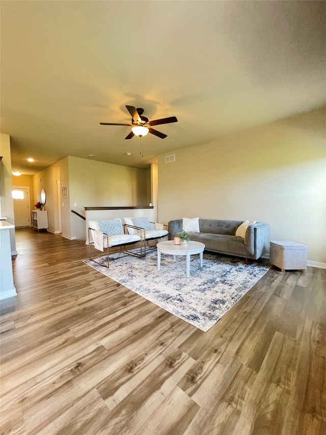 425 SE Hollow Ct, West Des Moines, IA 50265 - living area with visible vents, a ceiling fan, baseboards, and wood finished floors