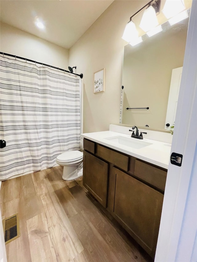 425 SE Hollow Ct, West Des Moines, IA 50265 - bathroom featuring visible vents, vanity, curtained shower, wood finished floors, and toilet
