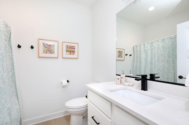 bathroom with wood finished floors, vanity, curtained shower, baseboards, and toilet