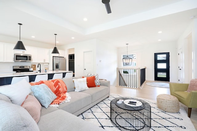 living area with light wood finished floors, a ceiling fan, and recessed lighting