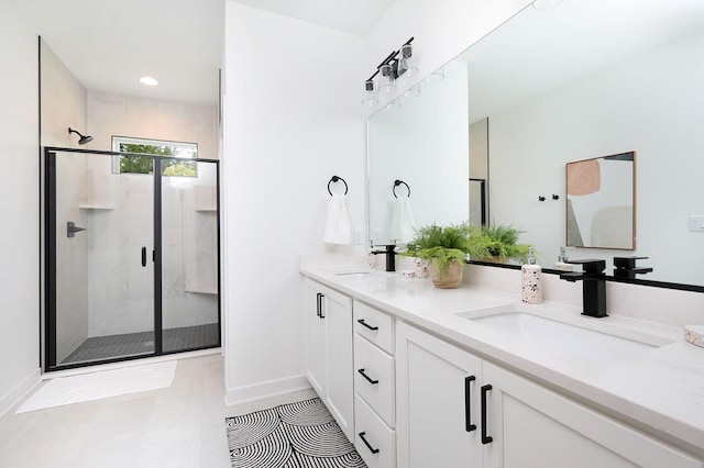 full bath featuring baseboards, a sink, double vanity, and a stall shower