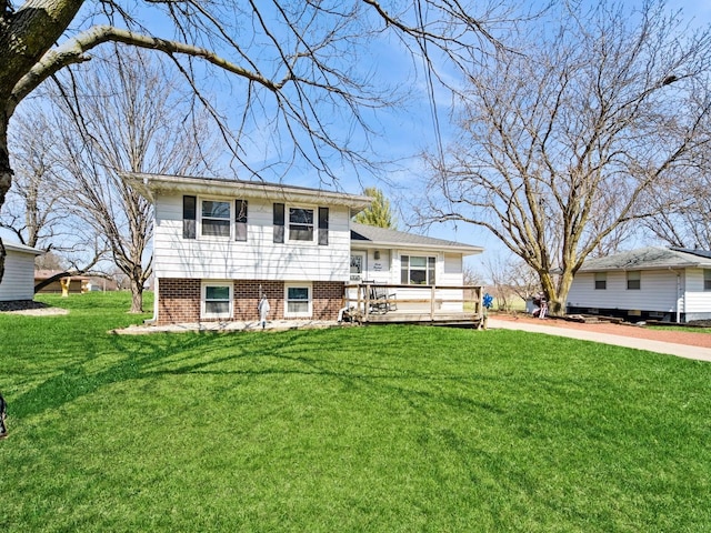 tri-level home featuring a front lawn and a wooden deck