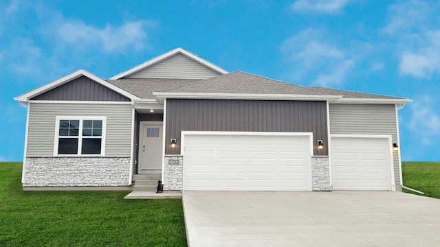 5508 NE Sienna Dr, Ankeny, IA 50021 - view of front of property featuring a garage, stone siding, driveway, a front yard, and roof with shingles
