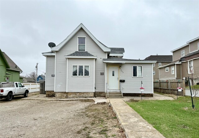 603 E Church St, Marshalltown, IA 50158 - view of front of home with a front yard, entry steps, fence, and roof with shingles