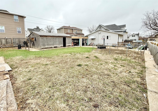 603 E Church St, Marshalltown, IA 50158 - rear view of property with a fenced backyard, an outdoor structure, a yard, and a shed