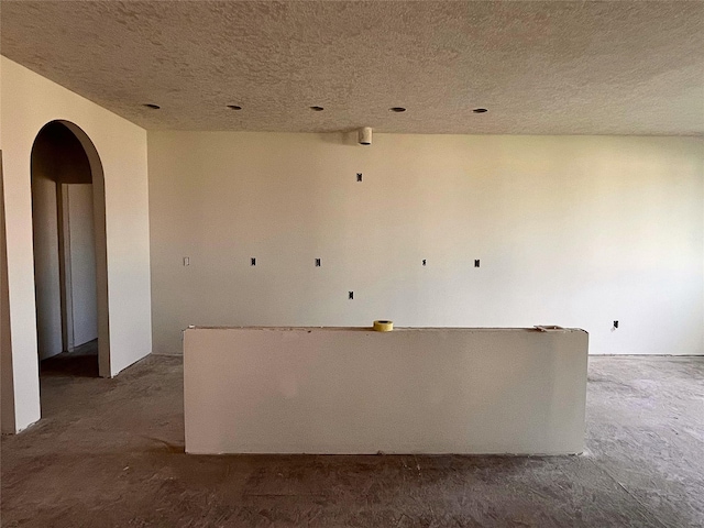 18048 Tanglewood Dr, Clive, IA 50325 - empty room featuring arched walkways and a textured ceiling