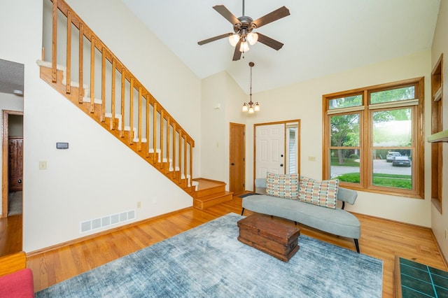 4774 Coachlight Dr, West Des Moines, IA 50265 - living room with wood finished floors, stairs, ceiling fan, high vaulted ceiling, and a chandelier